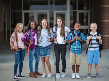  Students standing in a row with backpacks